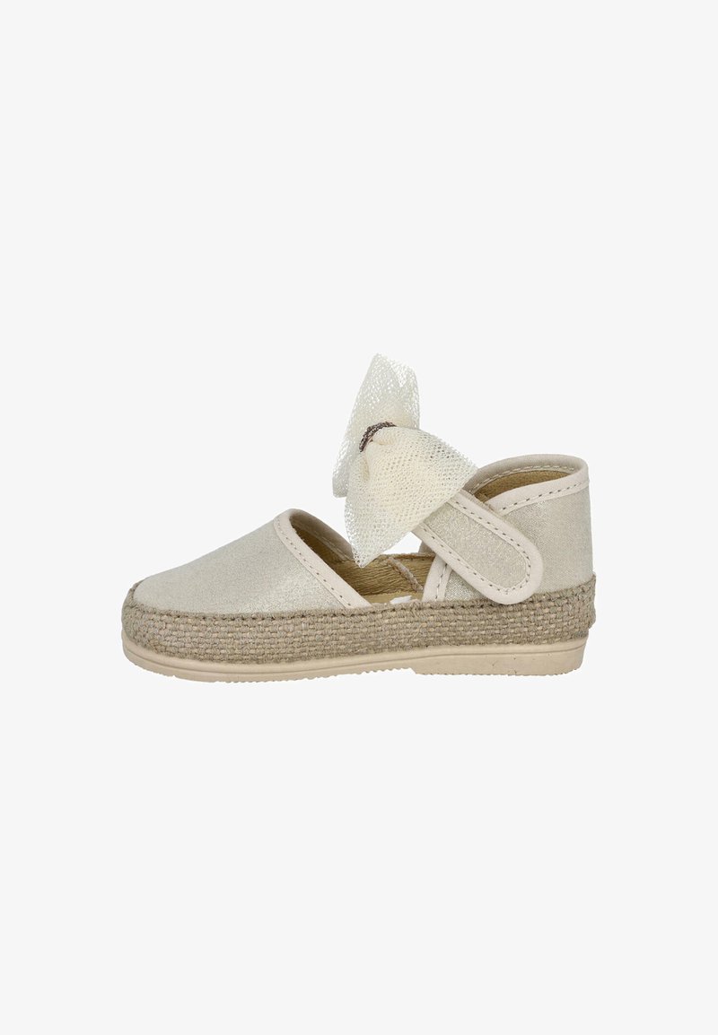 Zapato espadrille beige con suela de yute trenzada, parte superior de tela suave y un lazo de malla blanca. Cuenta con una correa ajustable para un ajuste seguro.