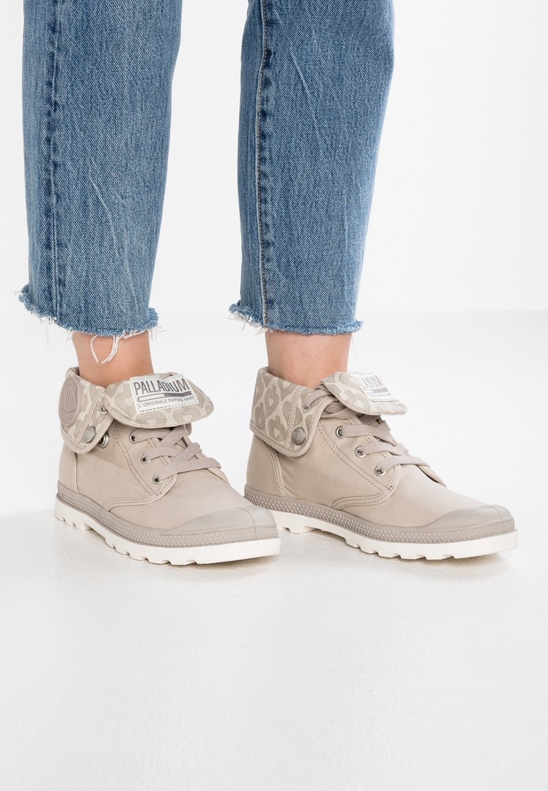 Sneaker high-top beige con colletto in tessuto a fantasia, punte in gomma e suola bianca. Design con lacci e logo sulla linguetta e sul colletto.