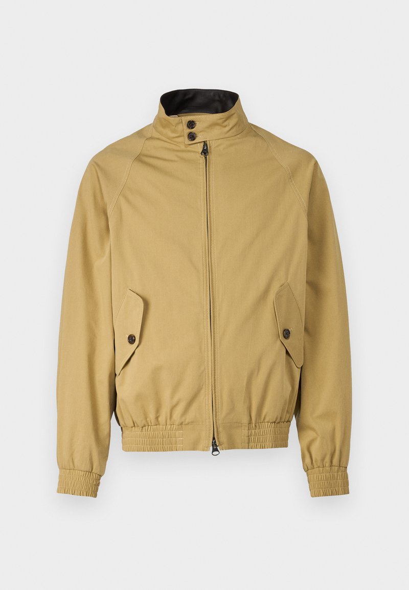 Beige Zip-Jacke mit hohem Kragen, zwei Seitentaschen und elastischen Bündchen sowie Saum. Die Materialien wirken glatt mit einem leichten Finish.