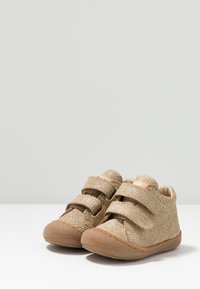Hellexturierte Kleinkinderschuhe mit doppelten Klettverschlüssen und runder Zehenform. Gummisohle und weiche Innenausstattung, mit dezentem Webmuster.
