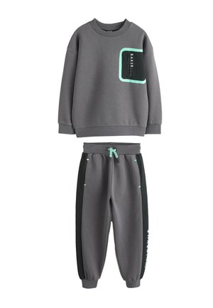 Tmavosivá súprava mikiny a nohavíc s mätovozelenými akcentmi a čiernymi bočnými panelmi, s nápisom "BAKER" na hrudi a nohavici.