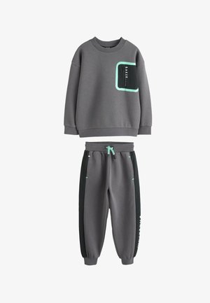 Mørkegråt sæt med sweatshirt og joggers med mintgrønne detaljer og sorte sidepaneler, med teksten "BAKER" på brystet og buksebenet.