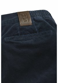 Navy corduroy pants with a textured surface, elastic waistband, and a brown leather label featuring "M5" on the back.