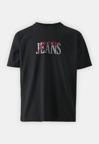 Camiseta de algodón negra con texto bordado en plateado y rojo "guess JEANS" en la parte frontal. Corte regular, diseño de cuello redondo y mangas cortas.