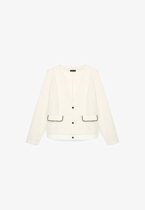 Weißer, strukturierter Langarmjacke mit V-Ausschnitt, drei schwarzen Knöpfen und zwei Fronttaschen, die mit schwarzem und goldenem Besatz umrandet sind.