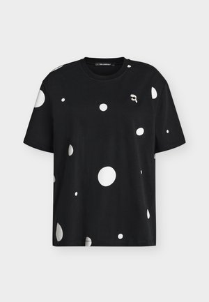 Μαύρο κοντομάνικο t-shirt με σκορπιστές μεγάλες και μικρές λευκές πουά και ένα μικρό λευκό γραφικό προσώπου με γυαλιά ηλίου κοντά στον γιακά.