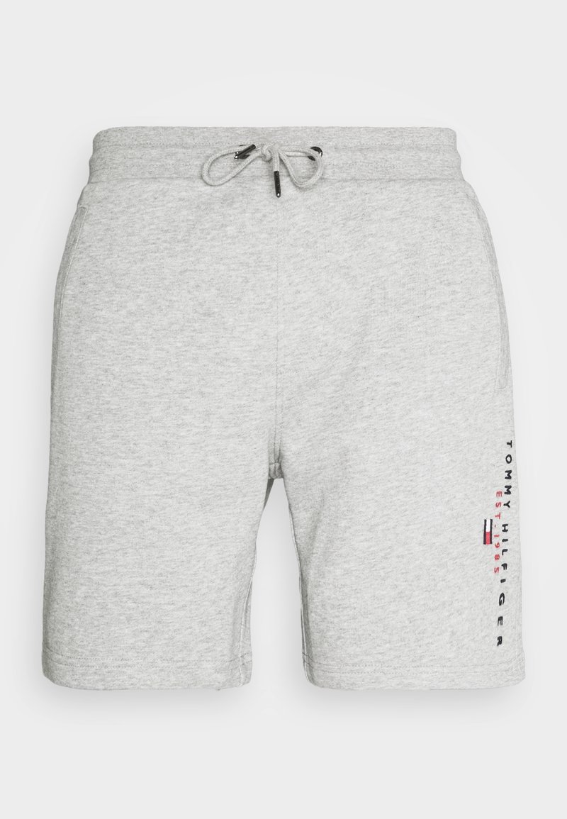 Shorts en coton gris clair avec taille à cordon, poches latérales et marquage vertical Tommy Hilfiger sur la jambe droite.