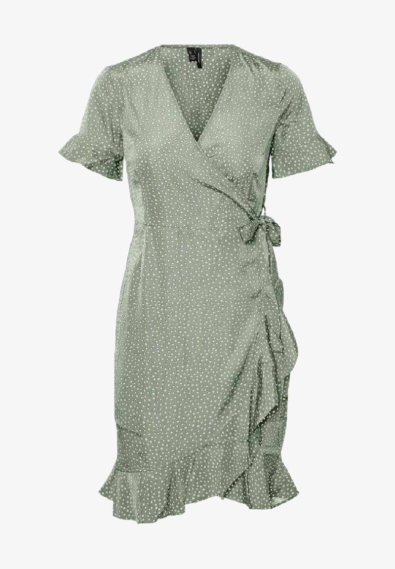 Robe portefeuille verte à pois blancs, manches courtes à volants, fermeture à nouer sur le côté et ourlet à volants.
