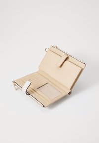 Portafoglio beige con chiusura a zip, scomparti interni per carte e una tasca trasparente per l'ID. Texture liscia con una tracolla removibile e dettagli a contrasto.