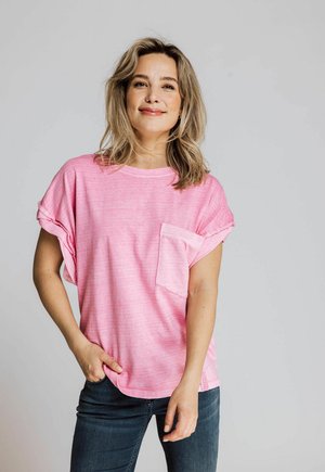 Light pink crew-neck t-shirt with short sleeves and a left chest pocket. Soft texture, relaxed fit, and rolled sleeve hems.