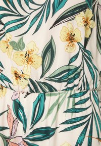 Floral fabric pattern with yellow flowers, green leaves, and teal palm fronds on a light beige background with gathered seam.