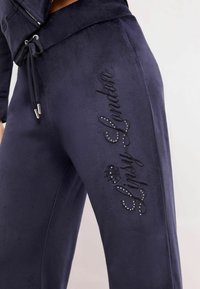 Sötétkék jogger nadrág puha anyagból, állítható derékhómmal, fekete hímzett "Lipsy London" felirattal és csillogó kiegészítőkkel.