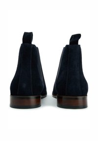 Navy blue suede chelsea boots with elastic side panels and pull tabs; wooden heels with a black rubber base.