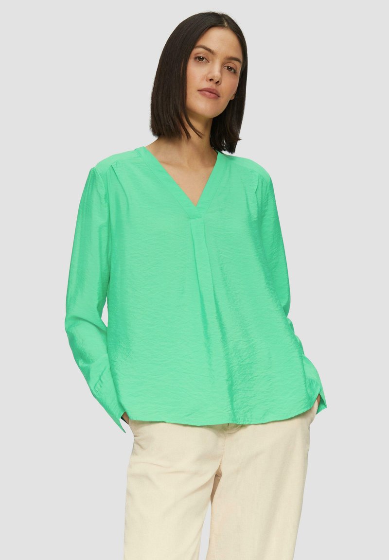 Groene blouse met lange mouwen en V-hals, van lichtgewicht, gestructureerde stof en met een relaxte pasvorm. Bevat zijsplitten en een subtiele plooidetail.
