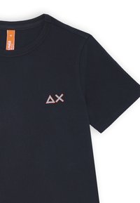 T-shirt in cotone blu navy con maniche corte, caratterizzato da un logo ricamato in forme geometriche arancioni e blu sulla parte sinistra del petto.