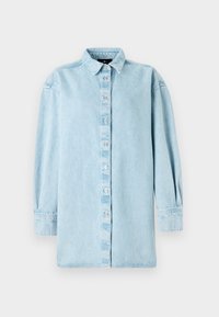 Lyseblå denimskjorte med knappelukking foran, lange ermer og klassisk krage. Har en litt løs passform og subtil tekstur.