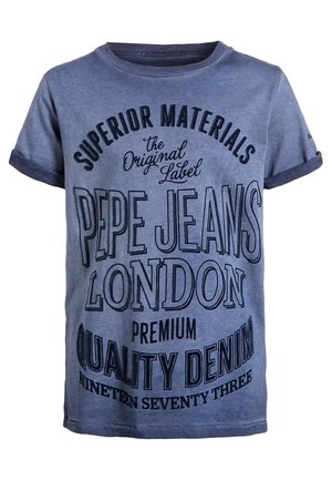 Niebieska koszulka z krótkim rękawem z podwiniętymi mankietami i czarnym tekstem: „Superior Materials, The Original Label, Pepe Jeans London, Premium Quality Denim, Nineteen Seventy Three.”