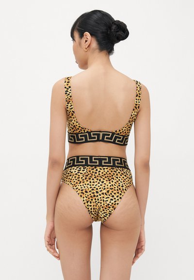 Leparda raksta bikini komplekts dzeltenā un melnā krāsā, ar platu elastīgu joslu ģeometriskas raksta un augsto vidukļa apakšdaļu dizainā.