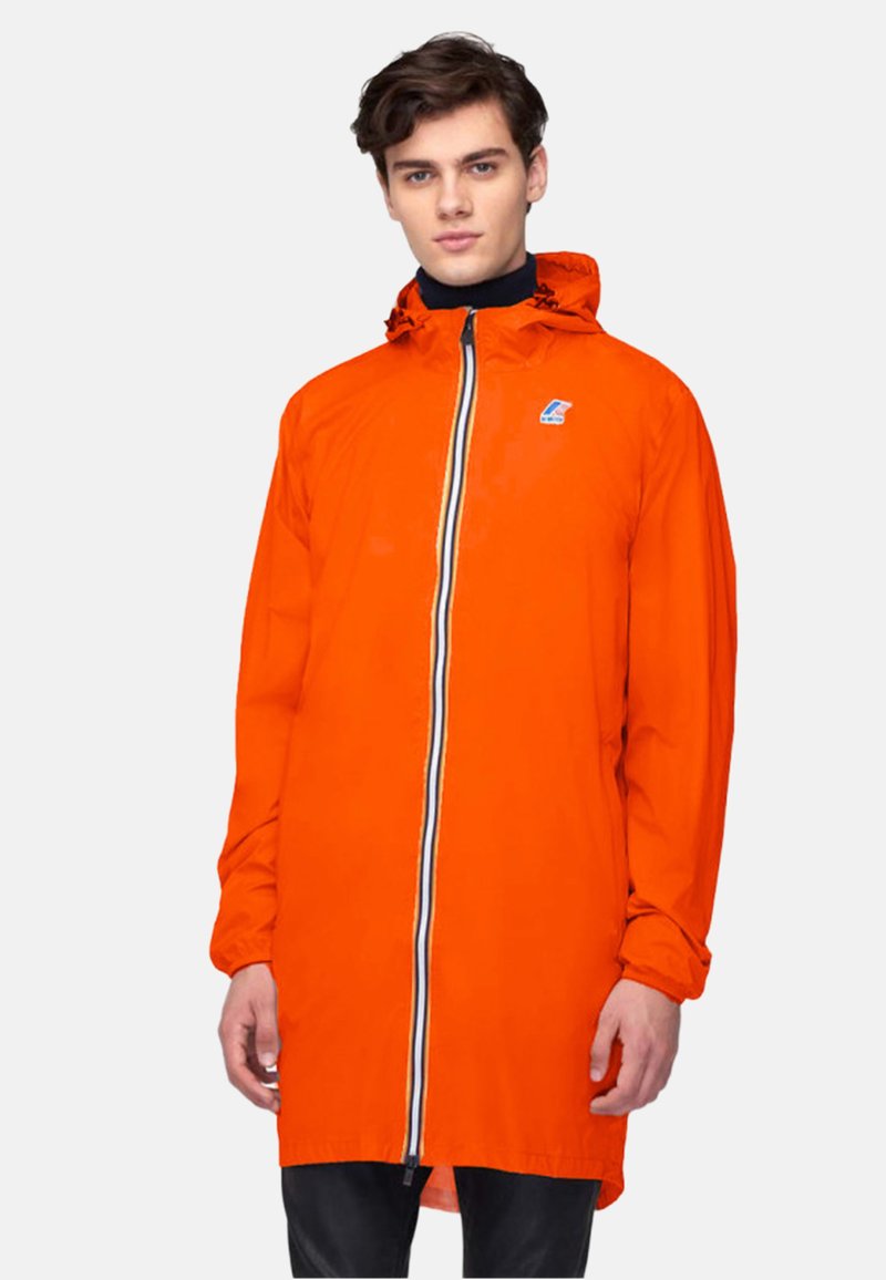 Veste orange en matériau léger et résistant à l'eau. Elle présente une fermeture éclair avec des rayures contrastées et une capuche.