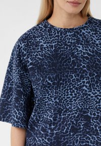 T-Shirt mit navyblauem und hellblauem gepunktetem Muster, rundem Rundhalsausschnitt und kurzen Ärmeln, aus weichem, leichtem Stoff gefertigt.