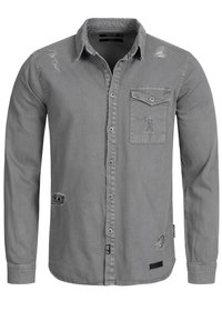 Grijs overhemd met knopen en twee borstzakken. Heeft distressed details, waaronder scheuren op de schouders en zijkanten. Gemaakt van katoen, met lange mouwen.