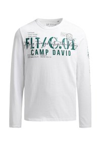 Long-sleeve white t-shirt, cotton fabric, featuring green graphics and text related to aviation and "Camp David" on the front and sleeve.