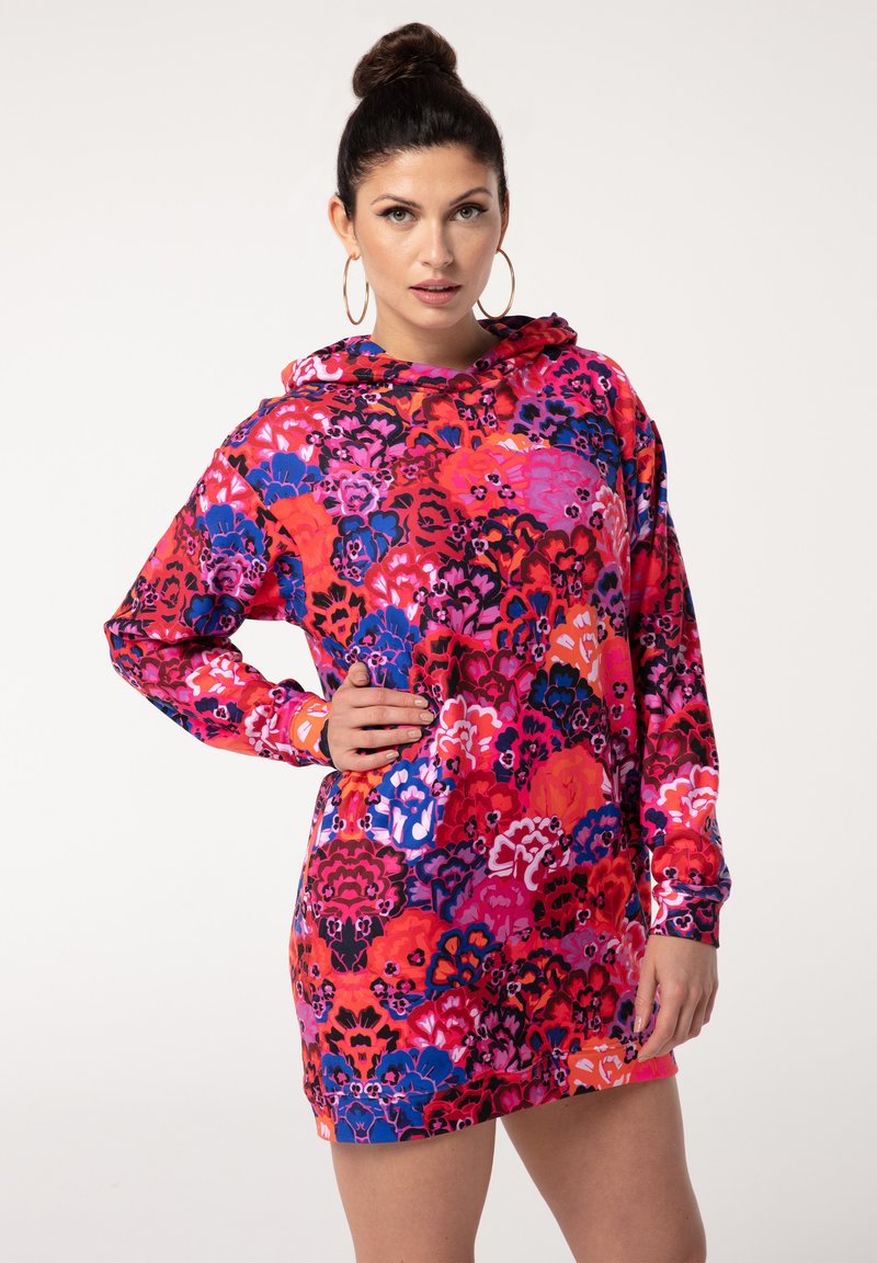 Kapuzenkleid mit lebhaftem Blumenmuster in Rot-, Pink- und Blautönen. Hergestellt aus weichem Stoff mit langen Ärmeln und lockerer Passform.