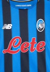 Μπλέ και μαύρη ριγέ φανέλα ποδοσφαίρου με το "Lete" σε κόκκινη γραμματοσειρά και το λογότυπο της Αταλάντα. Κατασκευασμένη από υλικό με υφή, διαθέτει στρογγυλή λαιμόκοψη.