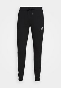 Schwarze Sweatpants aus Baumwollmischung mit elastischem Bund und Kordelzug, schmal zulaufenden Beinen und weißen Akzentstreifen. Adidas-Logo auf der Vorderseite.