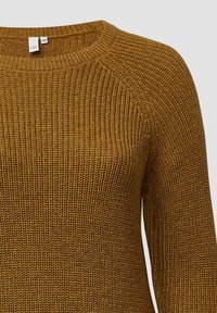 Mosterdgele gebreide trui met een ronde halslijn, ribbelstructuur en lange mouwen. Heeft raglan naden voor extra comfort.