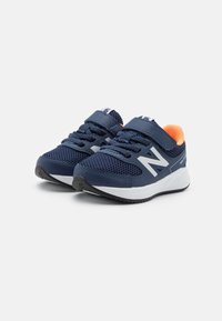 Granatowe sneakersy dziecięce New Balance z białymi podeszwami, z siateczkowego materiału, pomarańczowym podszyciem, sznurowadłami oraz rzepem na białym tle.