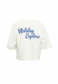 Camiseta blanca corta con mangas cortas. "Holiday Explore" impreso en cursiva azul en la parte posterior. Tejido suave, corte relajado.