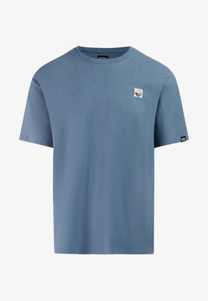 Blue short-sleeve crew neck t-shirt with a small rectangular logo patch on the left chest and a brand tag on the left sleeve hem.