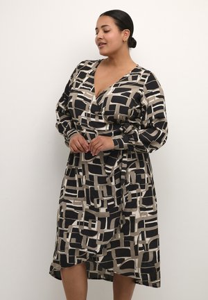 Abito a maniche lunghe avvolgente in un motivo astratto beige e nero. Presenta una scollatura a V e una silhouette fluida realizzata in un tessuto morbido e testurizzato.