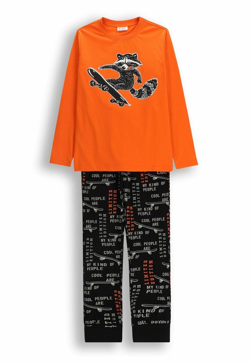 Pomarańczowa koszula z długim rękawem z grafiką szopa na desce do jazdy, połączona z czarnymi spodniami z wzorem desek do jazdy i białymi oraz pomarańczowymi napisami.