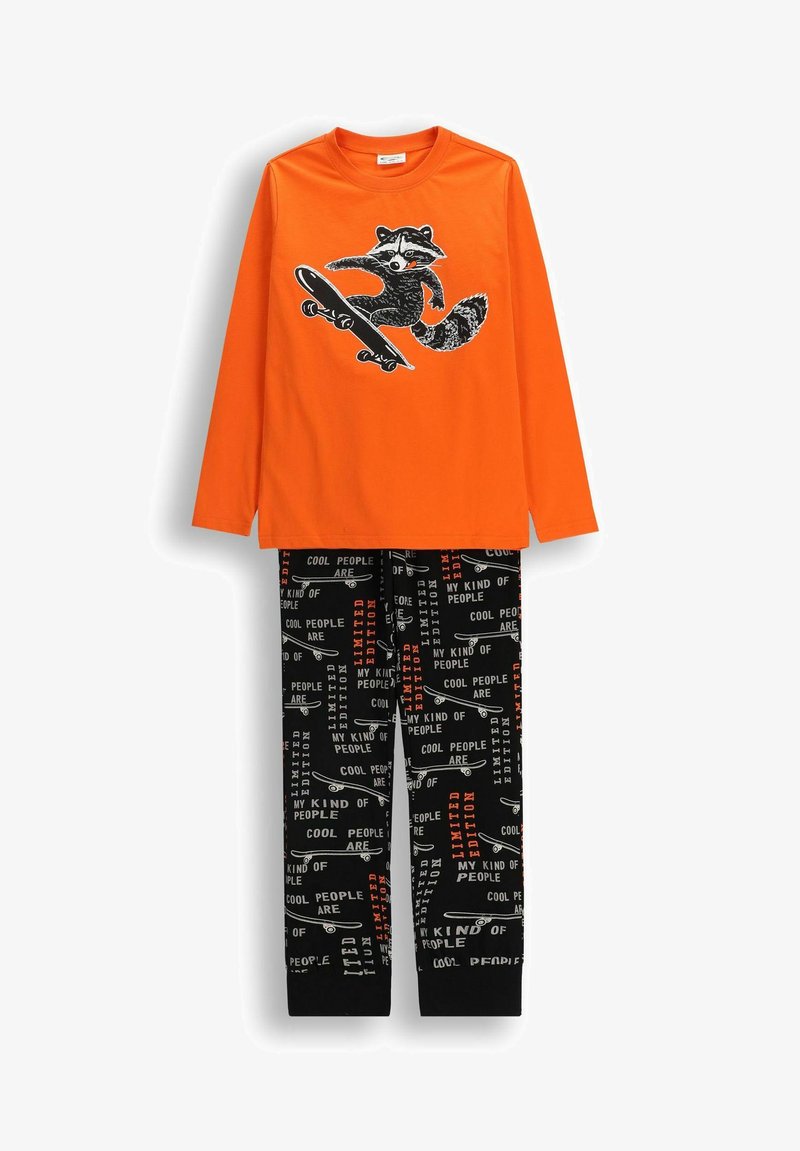 Pomarańczowa koszula z długim rękawem z grafiką szopa na desce do jazdy, połączona z czarnymi spodniami z wzorem desek do jazdy i białymi oraz pomarańczowymi napisami.