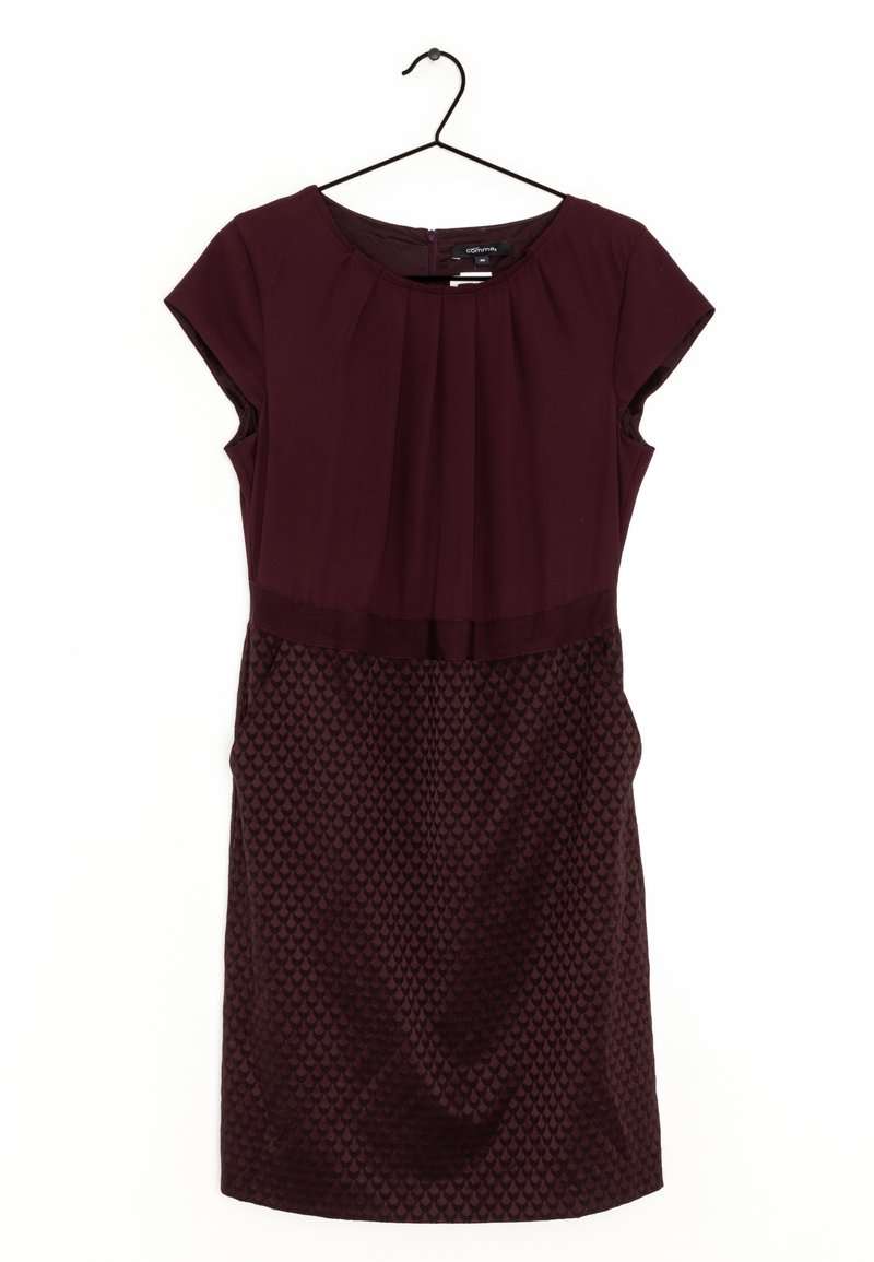 Robe courte manches courtes violet foncé avec corsage plissé et jupe texturée à motifs suspendue sur un cintre noir sur fond blanc.
