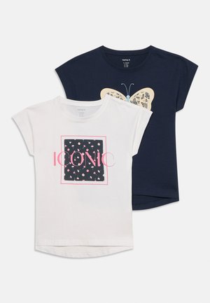 Dos camisetas de manga corta, una blanca con texto rosa "ICONIC" y un cuadrado floral, una azul marino con diseño de mariposa beige y azul.