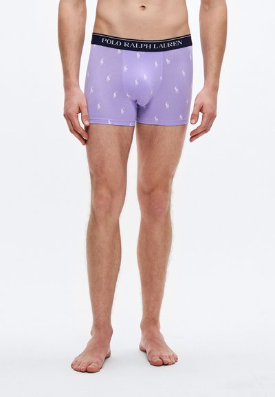 Lila boxeralsó fekete derékpánttal, rajta a "POLO RALPH LAUREN" felirattal. A szövet sima tapintású, apró fehér logókkal díszítve.