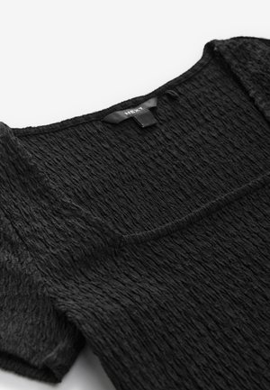 Sort tekstureret top med firkantet udskæring, med subtile krøllede detaljer og korte ærmer. Stoffet virker blødt og let.