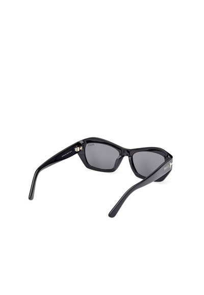 Gafas de sol negras angulares con montura brillante, lentes grises y acentos dorados en las patillas. Presenta un diseño de patas cónicas.