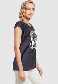 Mørkegrå kortærmet t-shirt med grafisk tryk af et kranium og tekst, lavet af bomuld med en afslappet pasform og rund halsudskæring.