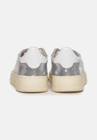 Sneaker con tomaia in paillettes argento e dettagli in pelle bianca, con suola in gomma beige e marchio impresso sul tallone.