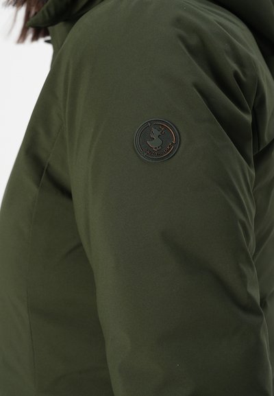 Manche d'une veste vert foncé avec un patch noir rond arborant un logo de canard et le texte "SAVE THE DUCK" sur le bras.