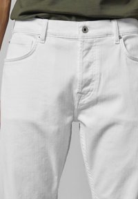 Valged denim püksid, kitsas lõige, viie taskuga, peene õmblusega ja metallist nööbi kinnitusega. Kangas on siledast tekstuurist.