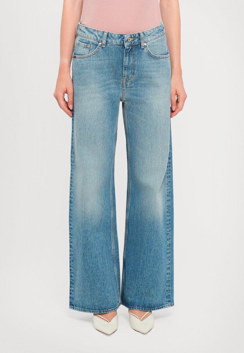 Wide-leg denim jeans in light blue, featuring a high waist, classic five-pocket design, and subtle fading along the legs.