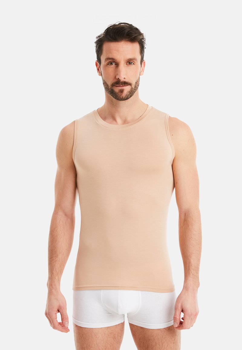 Nude sleeveless tank top made of smooth fabric, featuring a round neckline and a fitted design, paired with white underwear.