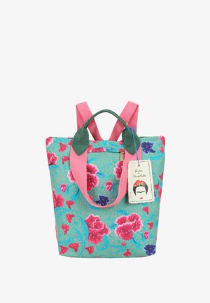 Borsa tote colorata con motivo floreale rosa, manici verdi, spallacci rosa e un'etichetta con un volto stilizzato che indossa una corona di fiori.