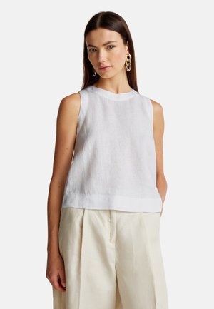 Witte linnen mouwloze top met een ronde hals en een iets losse pasvorm. Gecombineerd met lichtbeige geplooide broeken voor een ontspannen look.