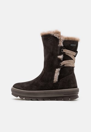 Ciemnobrązowy zamszowy zimowy but z futrzaną wyściółką, beżowe sznurówki owinięte wokół tyłu i gruba gumowa podeszwa, widok z boku.